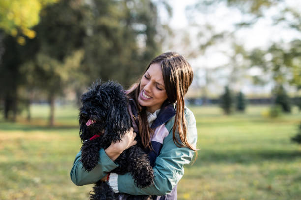 istock Happy woman carrying poodle 1300493203