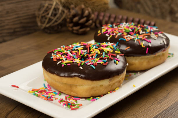 istock chocolate donuts on white plate and on wooden table 1300493301