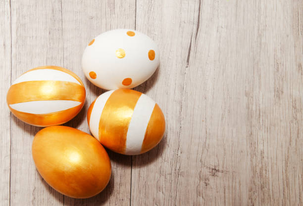 istock Perfect golden bright handmade painted easter eggs on a wood background. 1300495858