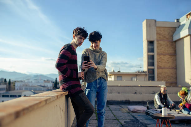 istock Joyful Couple Standing On Rooftop And Making Selfie 1300497138