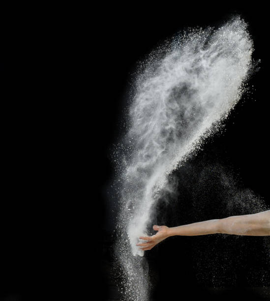 istock baker's hand throws a handful of white wheat flour on a black background 1300499191