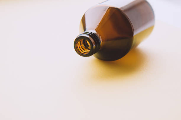 Macrophotos of a whiskey bottle in dim light on a wooden background.