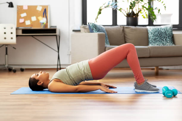 istock woman doing pelvic lift abdominal exercise at home 1300504533