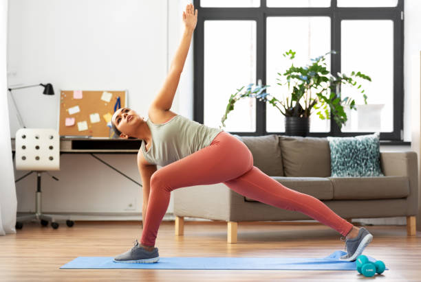 istock woman doing extended side angle yoga pose at home 1300504693