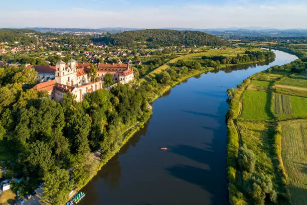 Tyniec near Krakow, Poland. Benedictine abbey, monastery and church on the rocky cliff and Vistula river with a canoe. Aerial view at sunset in summer