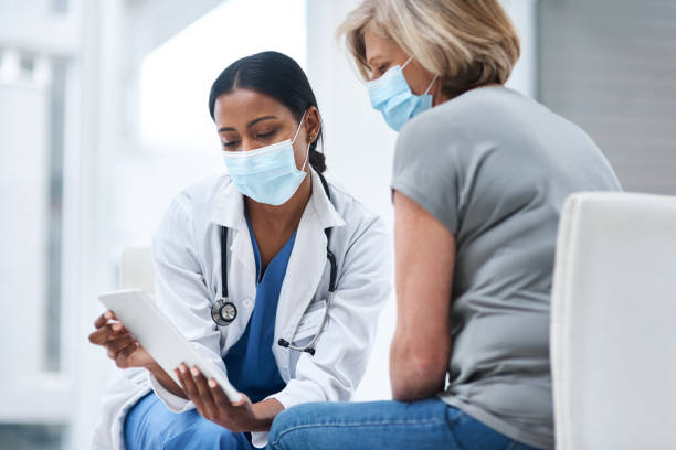 Diagnostic tools get a digital upgrade Shot of a young doctor using a digital tablet during a consultation with a senior woman medical examination stock pictures, royalty-free photos & images