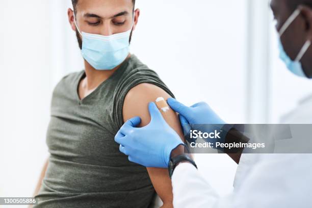 Gearing Up For A Global Scale Vaccination Stock Photo - Download Image Now - Vaccination, Adhesive Bandage, Men