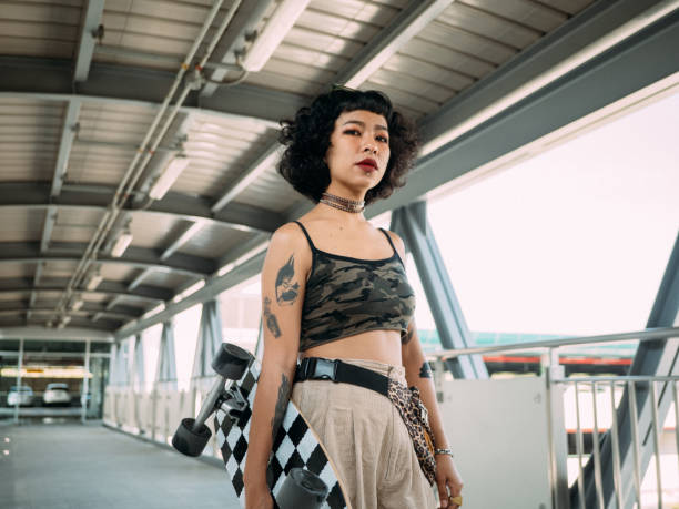 Hipster asian women going to play skateboarding.