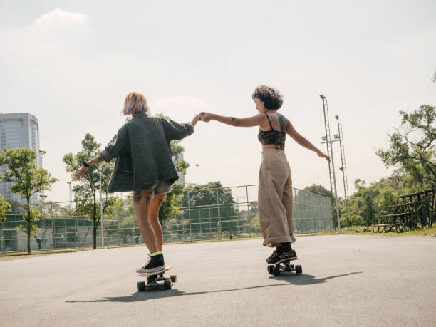 istock Young girls with riding longboard with friends 1300509571
