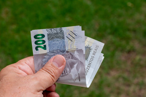 ブラジルの金札を持っている人。 - currency paper currency wealth one hundred dollar bill ストックフォトと画像