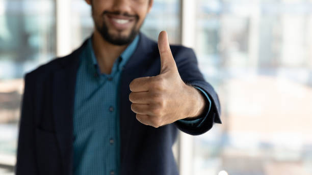 istock Close up of smiling ethnic man show thumb up 1300512212