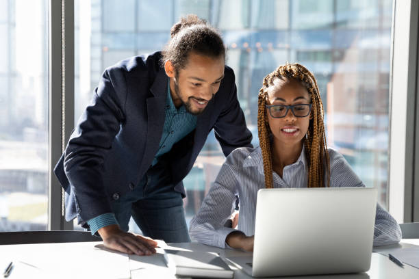 istock Smiling multiethnic colleagues work on laptop together 1300512231