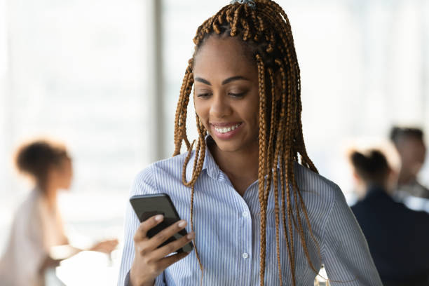 Smiling ethnic woman use smartphone texting online