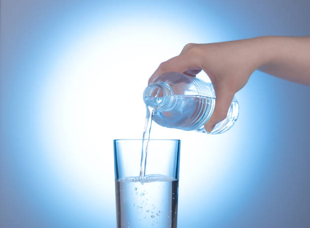 istock Plastic bottle with mineral water in a female hand. 1300512307