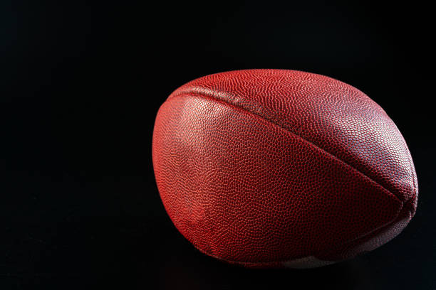 istock American foottball ball on dark background close up 1300514962