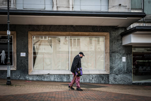 Lone old man wearing mask walking past closed down shop Mansfield, Nottingham UK January 2021

Lone old man wearing mask walking past closed down boarded up retail super store as town goes into recession and shops close under Covid 19 pandemic lockdown nottinghamshire stock pictures, royalty-free photos & images