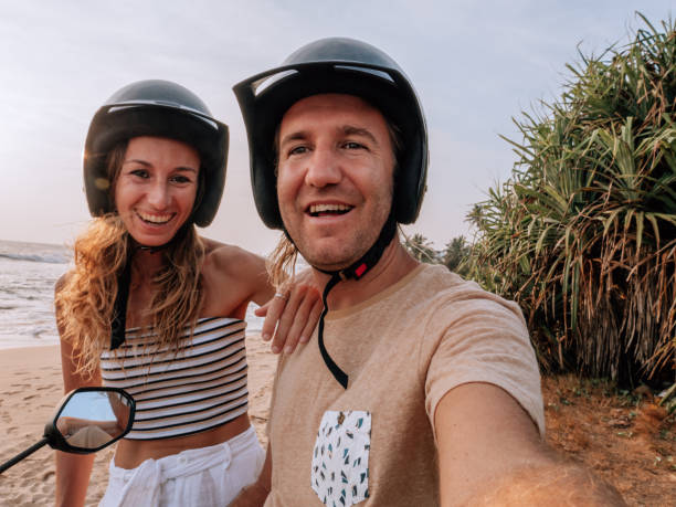 istock Couple take selfie on scooter by the beach at sunset 1300516768