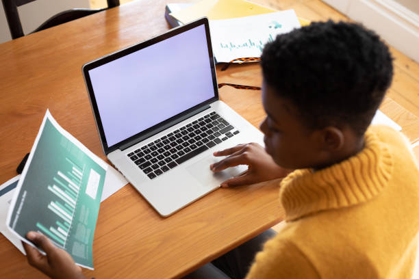 istock African american woman holding document using laptop while working from home 1300517665