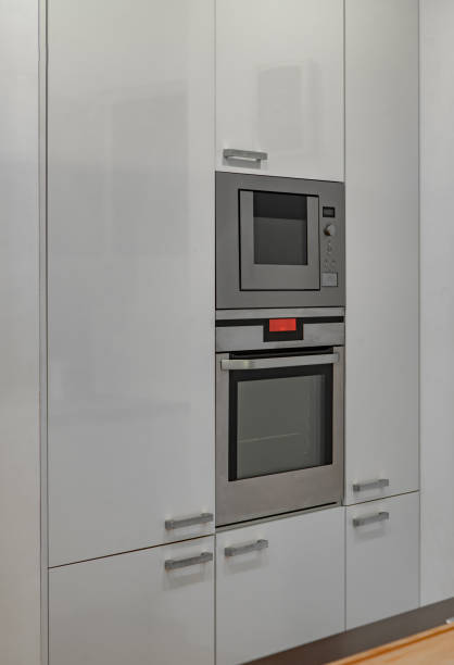 istock Modern interior of kitchen in luxury apartment. White cabinets. Built-in oven. 1300517751