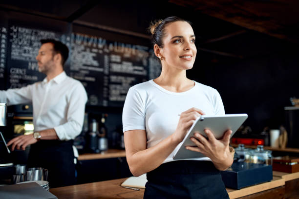 istock Portrait of restaurant manager standing with digital tablet at cafe 1300520454