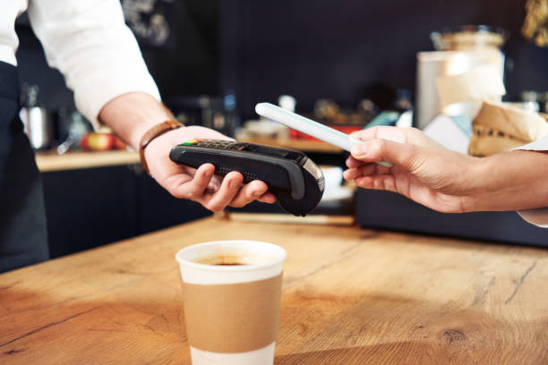 istock Contactless mobile payment with phone at cafe 1300520532