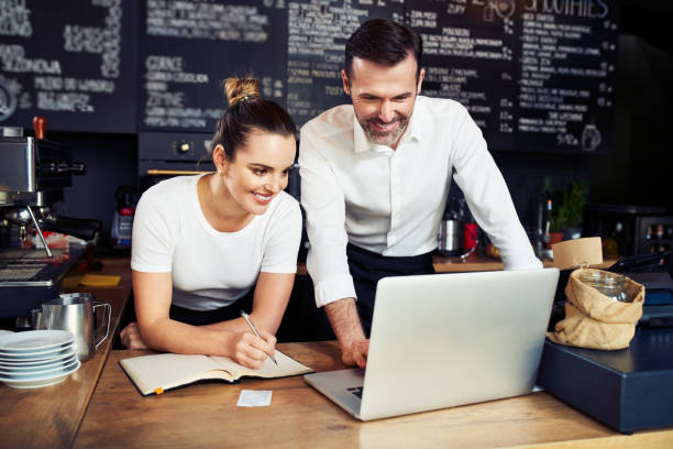 istock Small business bookkeeping. Two cafe owners calculating expenses with laptop 1300520656