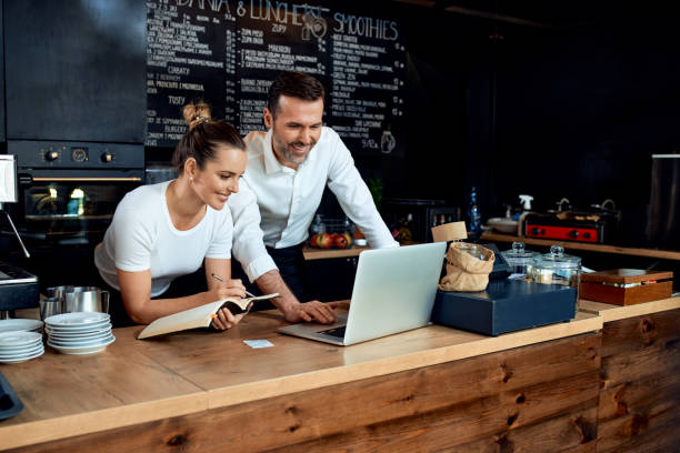 istock Happy small business owners working with laptop at cafe 1300521853