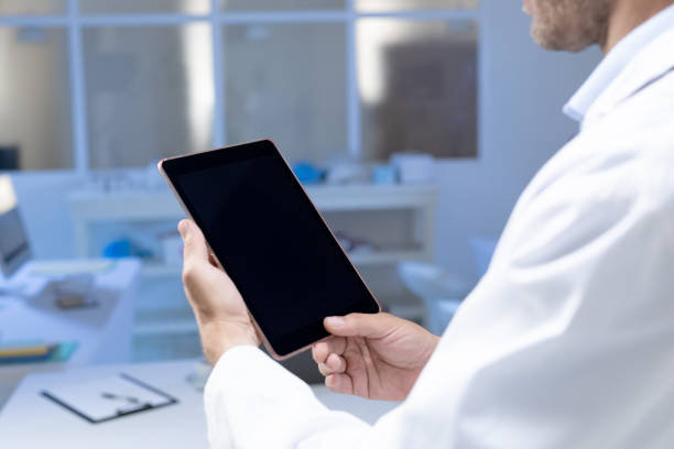 istock Midsection of caucasian male doctor making consultation video call using tablet 1300522366