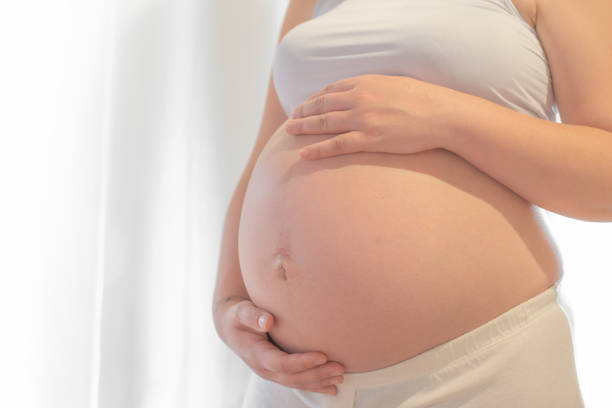 Pregnant woman with hand on belly. stock photo