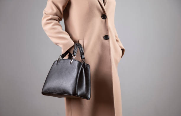 istock womanin coat holding bag 1300523458