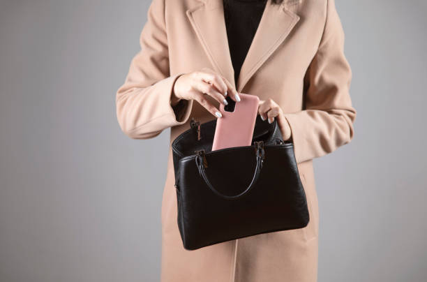 istock woman holding phone into bag 1300523461