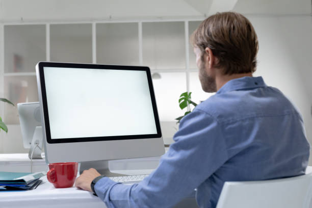 istock Rear view of caucasian businessman sitting at desk making video call using desktop computer 1300523761