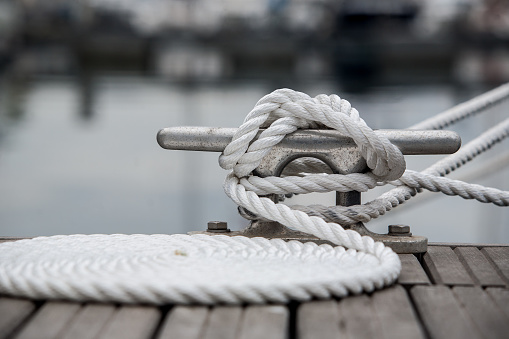 Mooring rope on mooring cleat. Coiled mooring line.
