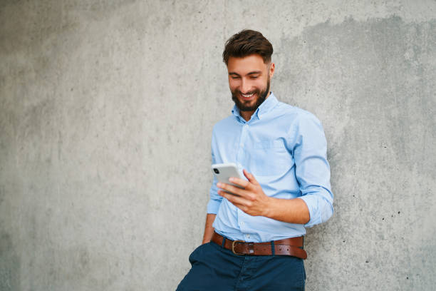 istock Handsome young businessman using smartphone while out in the city on break 1300525745