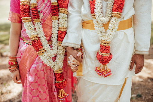 Wedding Couple with Indian Traditional Wedding Attires holding hands.