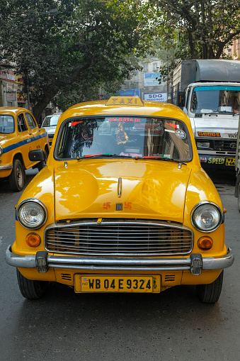Kolkata, India - February 2021: A taxi driving down a street in Kolkata on February 2, 2021 in West Bengal, India.