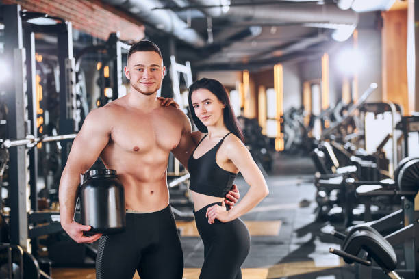 istock Cheerful motivated couple training in gym together 1300527413