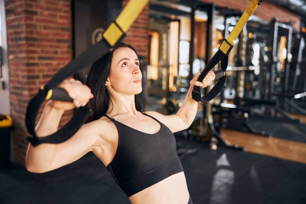 istock Young woman training with suspension webbing in studio 1300527969