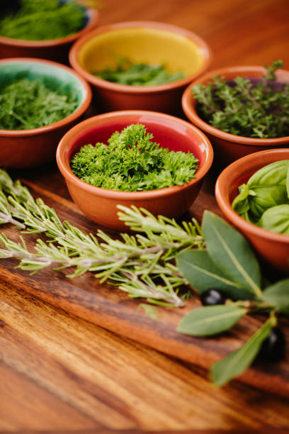 istock Herbs in bowls on a rustic wooden board with focus on the parsley with copy space 1300528704