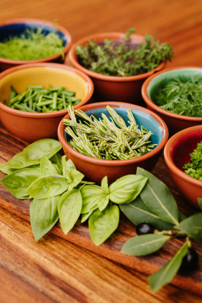 istock Herbs in bowls on a rustic wooden board with focus on the rosemary with copy space 1300528740