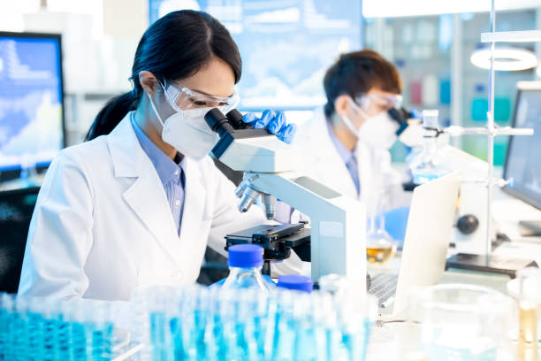 Asian scientist use microscope asian scientist female use microscope in the laboratory with her panter science research stock pictures, royalty-free photos & images