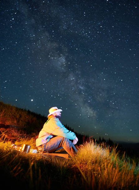 Recreation under night full starry sky in the mountains.