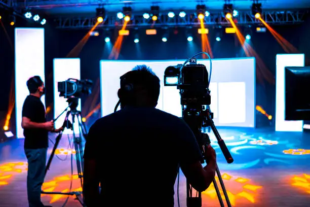 Professional cameraman - covering on event with a video, cameraman silhouette on live studio news, Selective focus