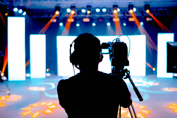 Professional cameraman - covering on event with a video, cameraman silhouette on live studio news, Selective focus Professional cameraman - covering on event with a video, cameraman silhouette on live studio news, Selective focus camera operator stock pictures, royalty-free photos & images