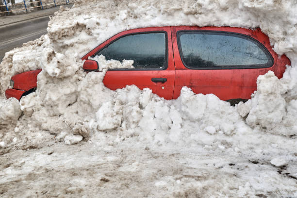 Red passenger car burried under the snow after heavy snowfall