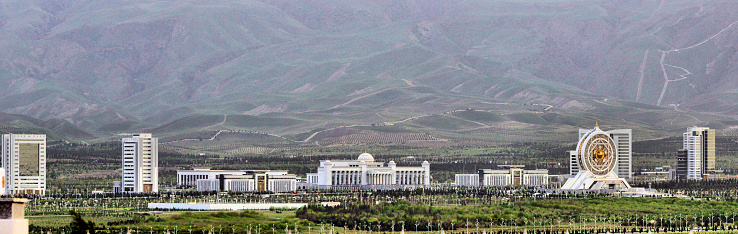 Ashgabat, Turkmenistan: skyline of the Archabil avenue government district - left to right: Automobile Agency, Turkmenhimiya State Concern, Customs Agency, Chamber of Commerce and Industry, Ministry of Justice, Alem Center, Ministry of Economy and Finance and Ministry of Railway Transport, in the background the footpaths of the 'Sedar Health Walk', on the slopes of the Kopet Dag mountains (also known as the Turkmen-Khorasan Mountain Range, mark the border with Iran).