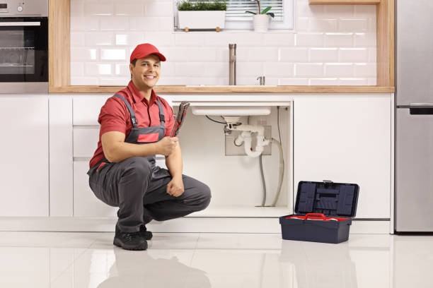 istock Plumber with a tool box kneeling next to a sink in a kitchen 1300535706