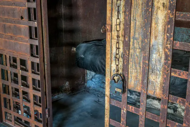 Photo of vintage jail cell with rusty bars