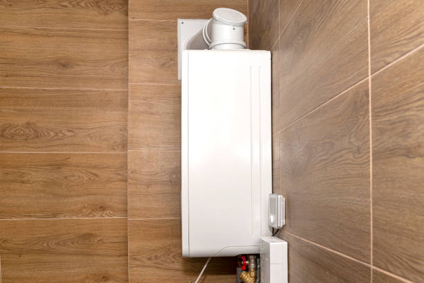 a modern gas boiler for natural gas, installed in a boiler room lined with ceramic tiles, visible pipe leading flue gas to the chimney. - flue gas imagens e fotografias de stock