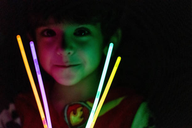 A boy playing with glow stick In lowlight front view glow stick stock pictures, royalty-free photos & images